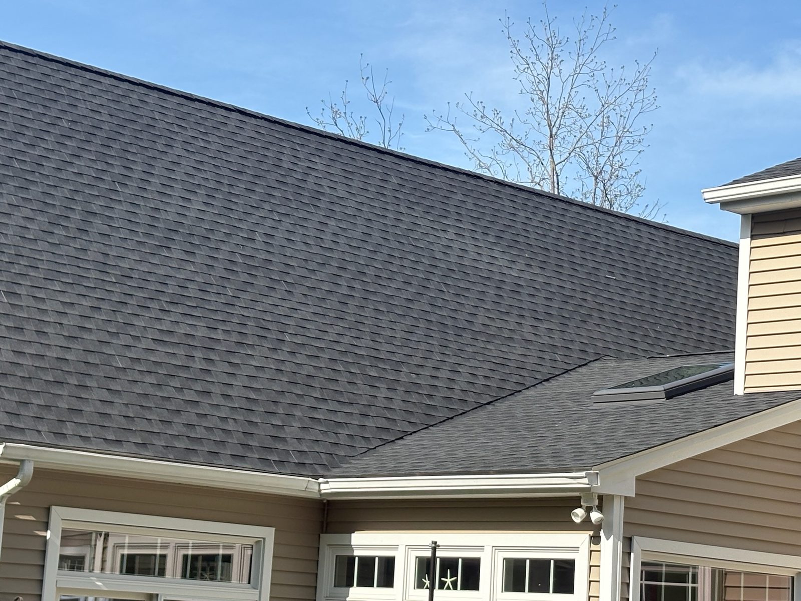 New seamless gutters and downspouts on a finished roof