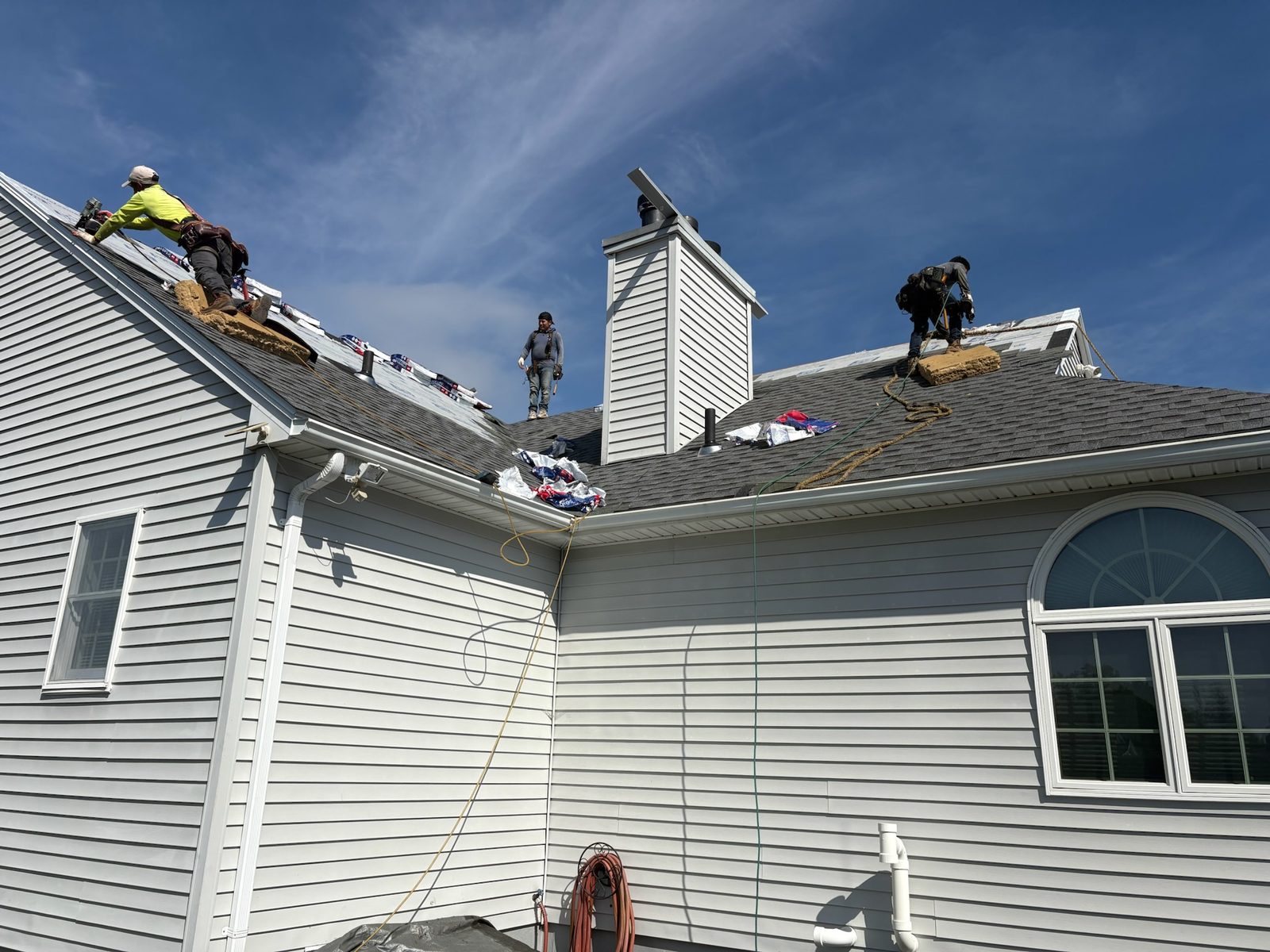 Roofing crew installing a new roof on a lakeside home